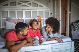 Smiling Family Lying On Bed