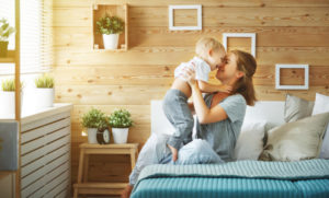 Happy Family Mother And Baby Son Toddler Laughing In Bed